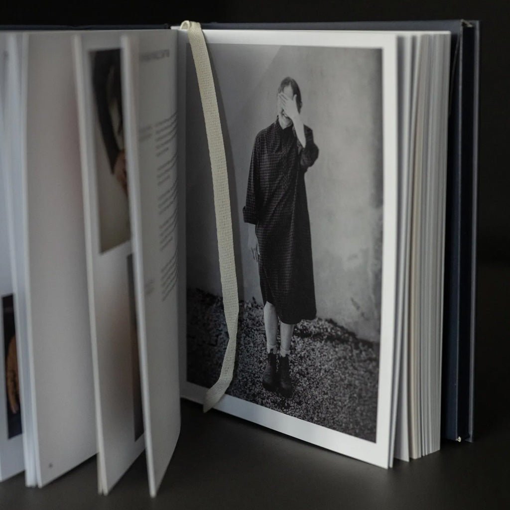 Open book with a black and white photograph of a person on a dark surface