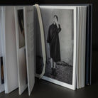 Open book with a black and white photograph of a person on a dark surface