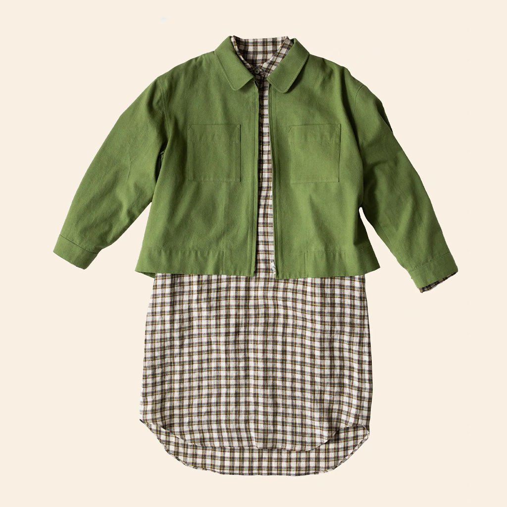 Green jacket over a plaid shirt on a beige background