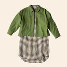 Green jacket over a plaid shirt on a beige background