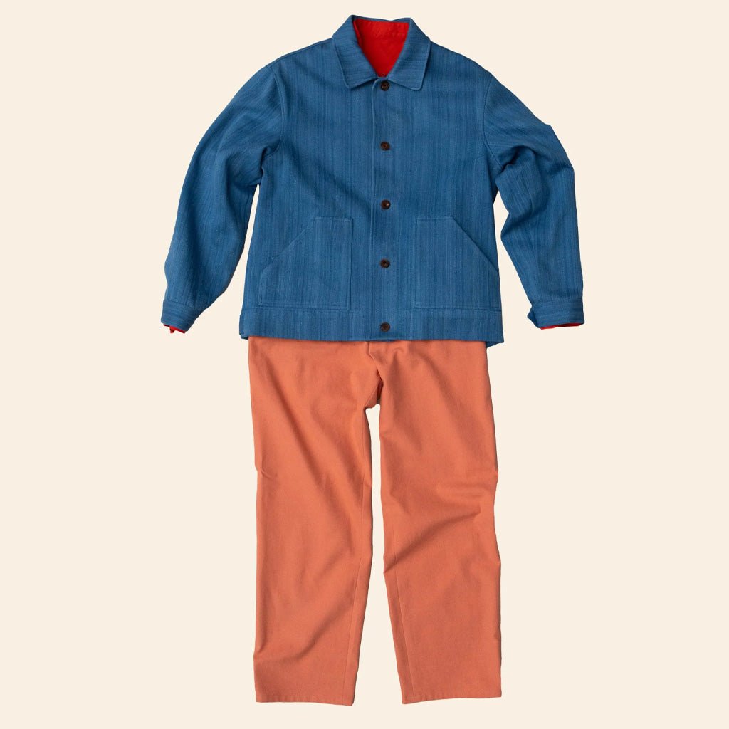 Blue jacket and orange pants on a beige background