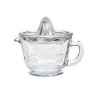 A clear glass measuring jug shown with a citrus juicer that rests on top.