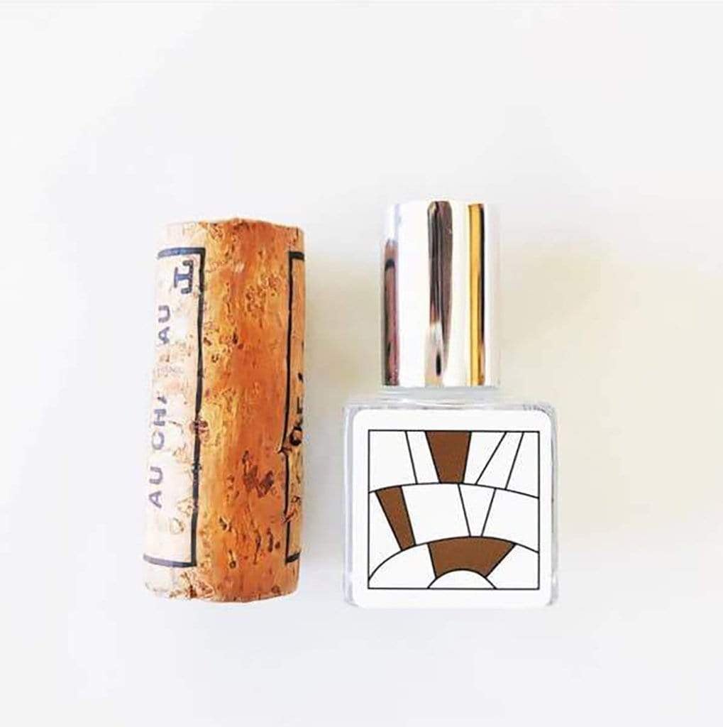 Bottle of oak perfume oil next to wine cork stopper