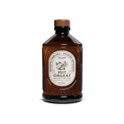 Brown bottle of orgeat syrup with a white label on a white background